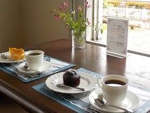 写真:コーヒーとケーキがそれぞれお皿に乗せられてる