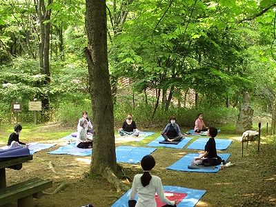 写真:ハンミョウ広場の木陰で足を組み呼吸を整える参加者たち