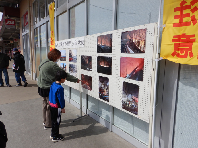 写真:令和7年岩手県大船渡市の林野火災活動状況の写真展示のを眺める親子の様子