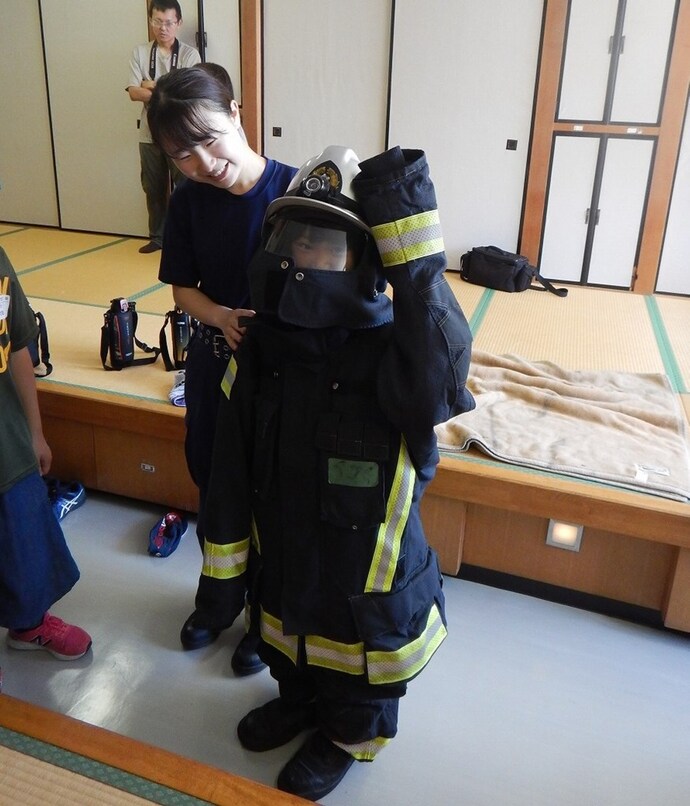 写真:防火衣と空気呼吸器の着装体験