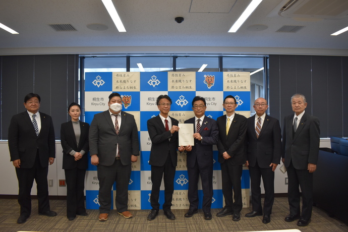荒木市長に提言書を提出する教育民生委員会のメンバーの写真