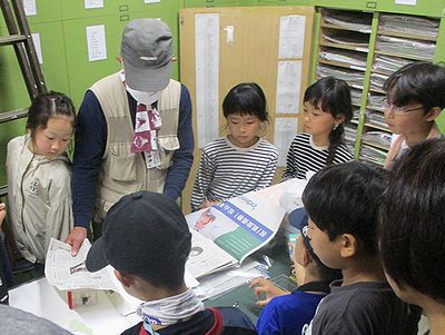 写真:たくさんの標本がつまった棚や管理方法を見学する親子