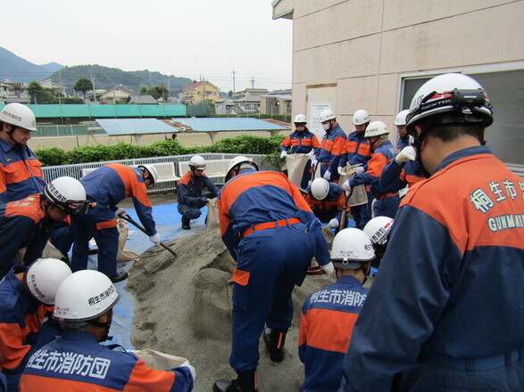写真:土をシャベルですくう消防職員