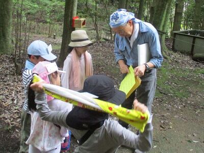 写真:木の郵便受けから出した手紙を子どもたちと広げている